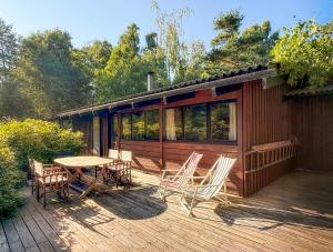 a cabin with a table and chairs on a deck at Architectdesigned 1976 Summer House Near Beach in Store Fuglede