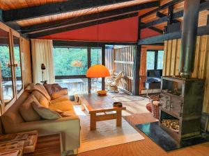 a living room with a couch and a fireplace at Architectdesigned 1976 Summer House Near Beach in Store Fuglede