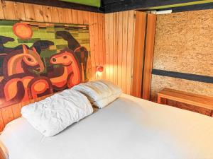 a bed in a room with a painting on the wall at Architectdesigned 1976 Summer House Near Beach in Store Fuglede +21 photos