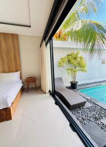 a bedroom with a bed and a swimming pool at Villa Reisya in Nusa Dua