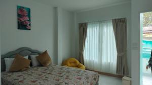 a bedroom with a bed with a large window at Aysaii Home02 in Panwa Beach +7 photos
