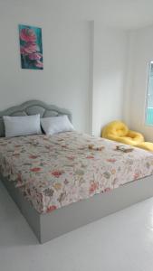 a bed with a floral comforter in a bedroom at Aysaii Home02 in Panwa Beach