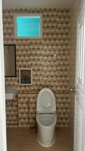 a bathroom with a white toilet and a window at Aysaii Home02 in Panwa Beach