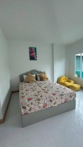 a bedroom with a bed and a yellow chair at Aysaii Home02 in Panwa Beach