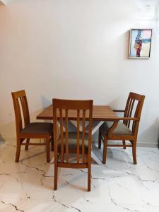 a dining room table with two chairs and a wooden table at krishna madhavam in Guruvāyūr