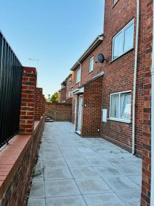 an empty sidewalk in front of a brick building at Cozy Grays Apartment in Grays Thurrock
