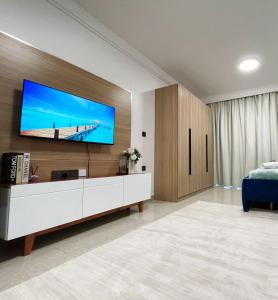 ein Wohnzimmer mit einem großen Fernseher an der Wand in der Unterkunft Sunset Stays near UN, Two Rivers & Village Market with Gym & Pool in Ruaka