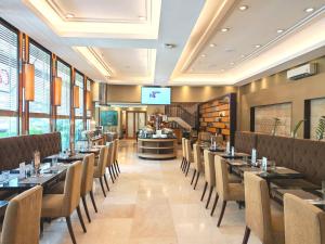 a restaurant with tables and chairs and a bar at City Garden Suites Manila in Manila