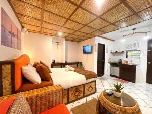 a bedroom with a large bed and a kitchen at Galera Lodge & Cafe in Puerto Galera