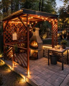 a wooden gazebo with an outdoor oven with lights at Wild House in Sinaia