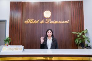 a woman standing at a table in front at Laimeront Hotel Dalat Vietnam in Da Lat