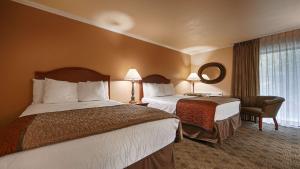 a hotel room with two beds and a mirror at Best Western Miners Inn Yreka in Yreka