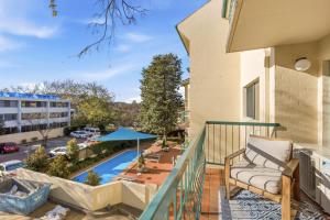 a balcony with a couch and a view of a pool at Stylish 2-Bed Apartment in Kingston in Kingston 