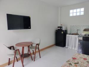 a living room with a table and chairs and a kitchen at Aysaii Home01 in Panwa Beach