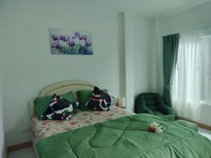 a bedroom with a bed and a green chair at Aysaii Home01 in Panwa Beach