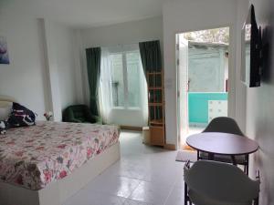 a bedroom with a bed and a table and a window at Aysaii Home01 in Panwa Beach
