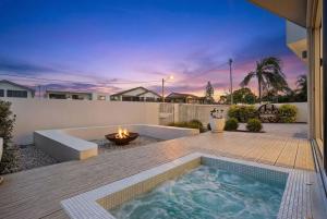 a backyard with a hot tub and a fire pit at The Grand Ocean Vista in Shellharbour