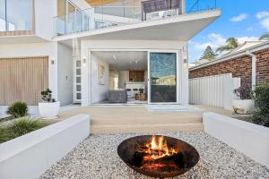 a house with a fire pit in the middle of a yard at The Grand Ocean Vista in Shellharbour