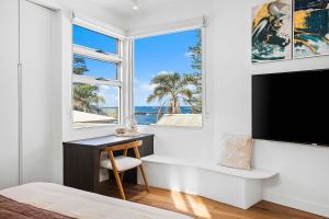 a bedroom with a desk and a tv and a window at The Grand Ocean Vista in Shellharbour +26 photos