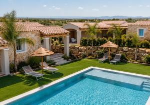 a backyard with a swimming pool and a house at Calarè Boutique Rooms - Adults Only in Cala Sinzias