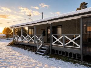 ein Gebäude mit Zaun im Schnee in der Unterkunft Bronte Snug in Bronte