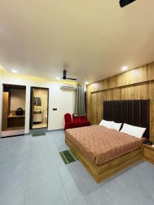 a bedroom with a bed and a red chair at Hotel RK Gharana Inn in Siwān