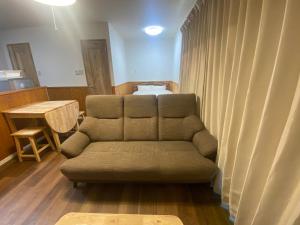 a living room with a couch and a bed at Bise House in Motobu