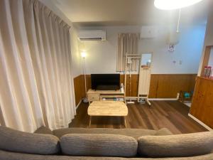 a living room with a couch and a table at Bise House in Motobu
