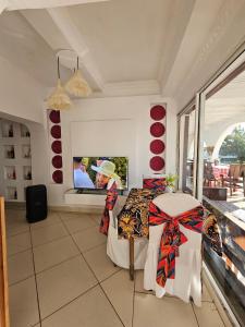 a room with a table and a tv on the wall at Le Port Hotel in Fort Dauphin