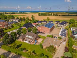 an aerial view of a home with solar panels on its roofs at Bauernhof Lafrenz, Ferienhäuser & Hofcafé in Fehmarn