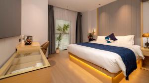 a bedroom with a large bed and a window at 啡诺艺术美居 in Guangzhou