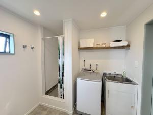 a bathroom with a sink and a shower at Whangaroa Barn in Whangaroa +40 photos