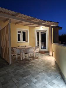 a patio with a table and chairs under a pergola at Case Vacanza il Sole in La Maddalena