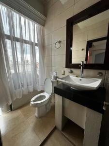 a bathroom with a toilet and a sink and a mirror at Hotel kristal in La Barca