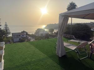 a view of a lawn with a tent and a chair at Villettine le Marie in Ricadi