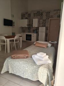 a bedroom with two beds and a kitchen with a table at Case Vacanza il Sole in La Maddalena