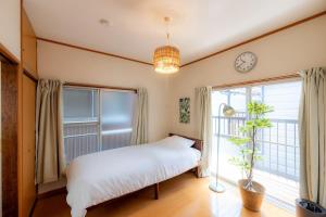 a bedroom with a bed and a clock on the wall at Kokonimo Niiza in Niizo