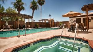 a swimming pool in a resort with palm trees at Best Western Colorado River Inn in Needles