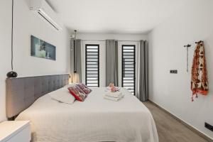 a white bedroom with a large bed with white walls at Ocean View Apartment 384 Blue Bay in Dorp Sint Michiel