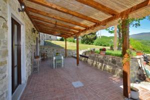 an outdoor patio with a wooden pergola at Dimora Belfiore - Happy Rentals in Capolona