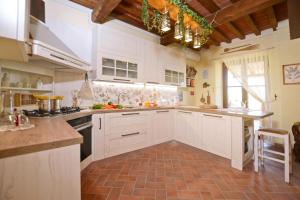a kitchen with white cabinets and a brick floor at Dimora Belfiore - Happy Rentals in Capolona