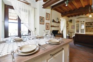 a kitchen with a table with plates and wine glasses at Dimora Belfiore - Happy Rentals in Capolona
