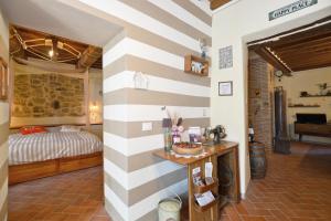 a bedroom with a striped wall with a bed at Dimora Belfiore - Happy Rentals in Capolona