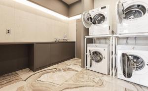 a laundry room with two washer and dryer at ALMOND Hotel in Jinju