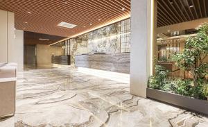a lobby with a stone floor in a building at ALMOND Hotel in Jinju