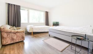 a bedroom with a large bed and a couch and a chair at Helmiapartments Sotkamo in Sotkamo