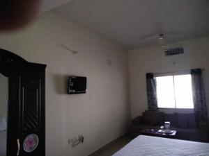 a bedroom with a bed and a tv on the wall at Hotel Awadh Fort in Patna