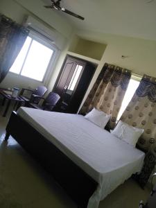 a bedroom with a large bed and two windows at Hotel Awadh Fort in Patna