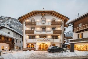 a black car parked in front of a building at Hotel Flora in Selva di Val Gardena