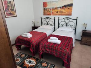 two beds in a room with towels on them at BUONUMORE-la QUIETE in Acquapendente